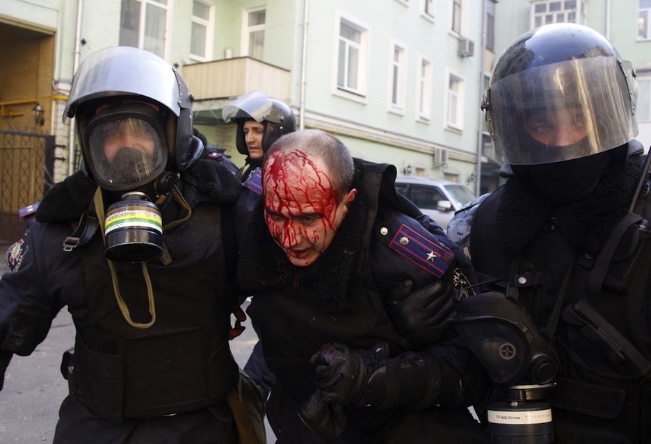 Un agente herido es trasladado por sus compañeros. (Anatolii STEPANOV /AFP PHOTO)