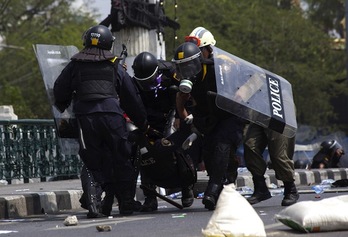 Varios policías trasladan a un compañero herido en las protestas. (KC ORTIZ/AFP PHOTO)
