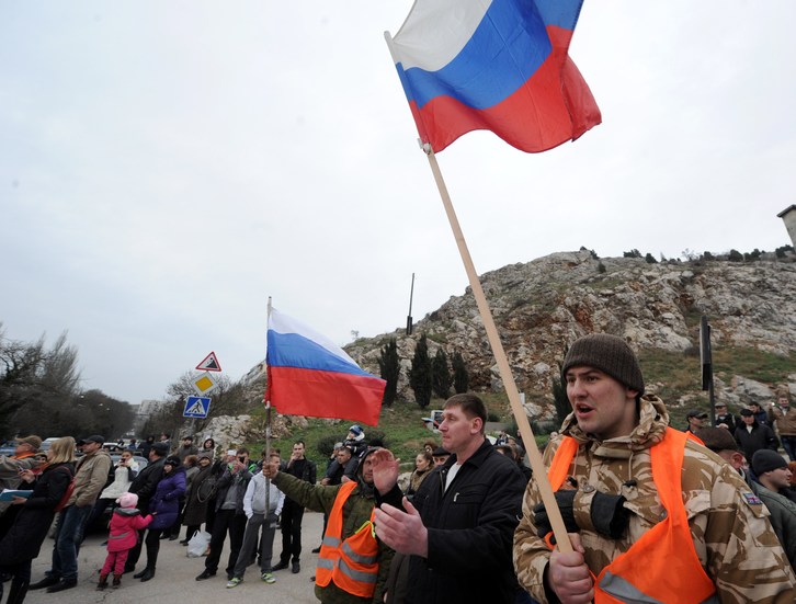 Hombres uniformados sin identificación y con banderas rusas bloquean una base en la frontera ucraniana. (Viktor DRACHEV / AFP)
