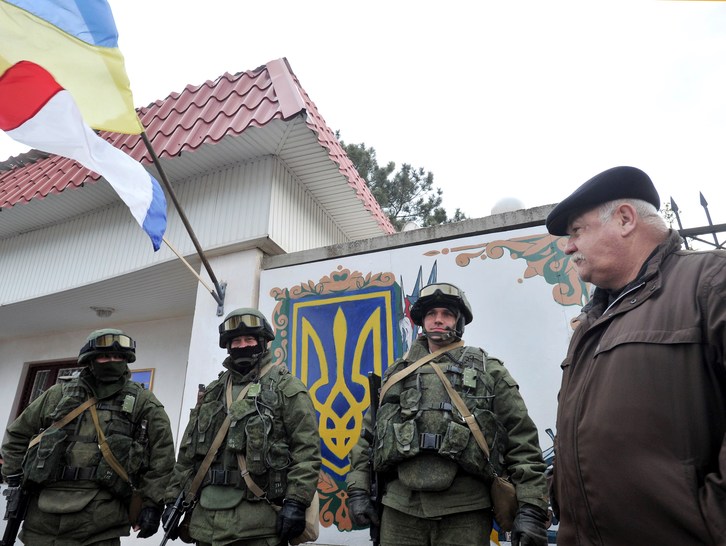 Hombres uniformados sin distintivos bloquean los cuarteles militares ucranianos. (Viktor DRACHEV / AFP)