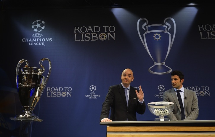 El secretario general de la UEFA, Gianni Infantino, junto con el exinternacional portugués Luis Figo, durante el sorteo de cuartos. (Fabrice COFFRINI/AFP)