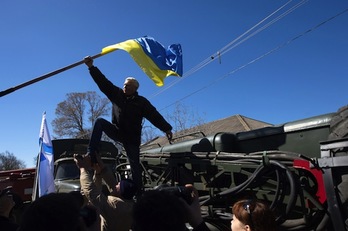 Crimeos retiran la bandera de Ucrania en una base aérea. (Dmitry SEREBRYAKOV/AFP PHOTO)