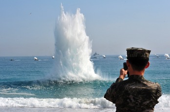 Un soldado surcoreano observa cómo se aproximan vehículos anfibios de combate hacia la costa. (Jung YEON-JE/AFP) 