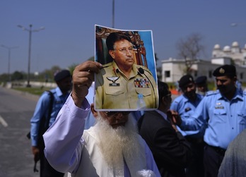 Un seguidor sostiene un retrato de Musharraf en las inmediaciones del tribunal. (Aamir QURESHI/AFP PHOTO)