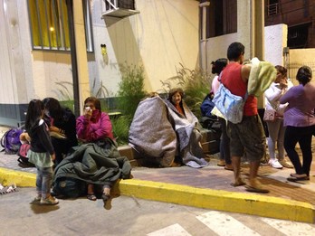 Afectados por el terremoto esperan a ser atendidos frente a un local habilitado para ello. (Francesco DEGASPERI/AFP)