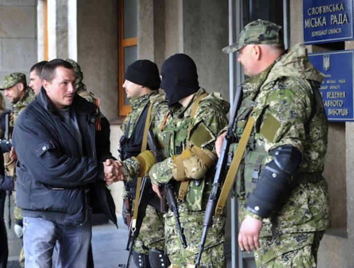 Un habitante de Slavyansk, al este de Ucrania, saluda a hombres prorrusos armados. (Genya SAVILOV / AFP PHOTO) 