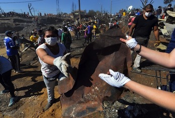 Voluntarios trabajan en una zona de Valparaíso devastada por el fuego. (Martin BERNETTI/AFP PHOTO)
