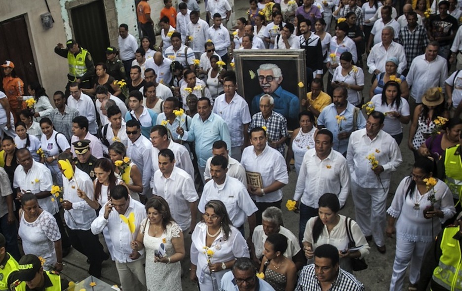 Zuriz jantzita eta larrosa horiak eskuan Aracatacan. (Joaquin SARMIENTO / AFP)