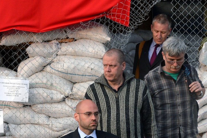 Representantes de la OSCE y el militar sueco abandonan el lugar, donde estaba retenido. (AFP)