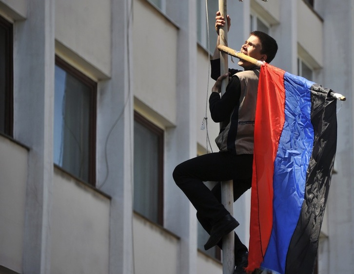 Un activista intenta colgar la bandera rusa en la ciudad de Mariupol. (Genya SAVILOV/AFP)