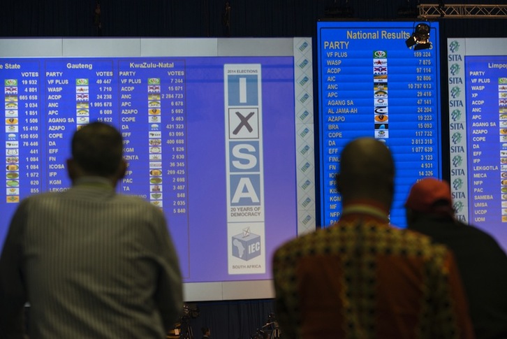 Un grupo de personas observa los resultados electorales en Pretoria. (Mujahid SAFODIEN/AFP)