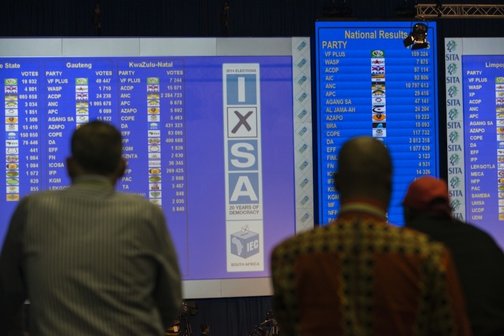 Un grupo de personas observa los resultados electorales en Pretoria. (Mujahid SAFODIEN/AFP) 