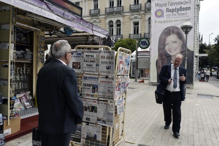 Un hombre consulta los titulares sobre las elecciones, en Atenas. (Louisa GOULIAMAKI/AFP PHOTO)