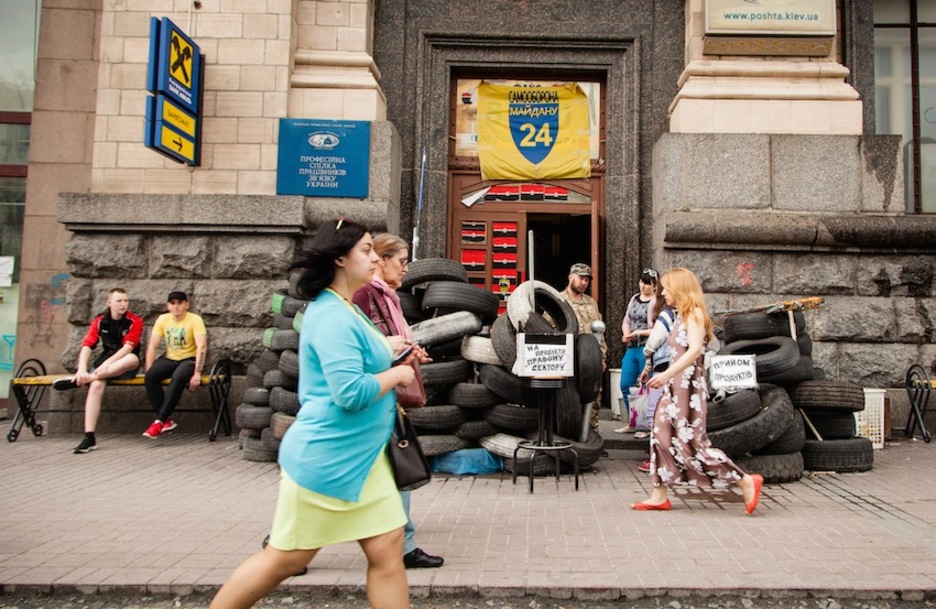 Ciudadanos ucranianos pasan ante un edificio ocupado. (Juan TEIXEIRA)