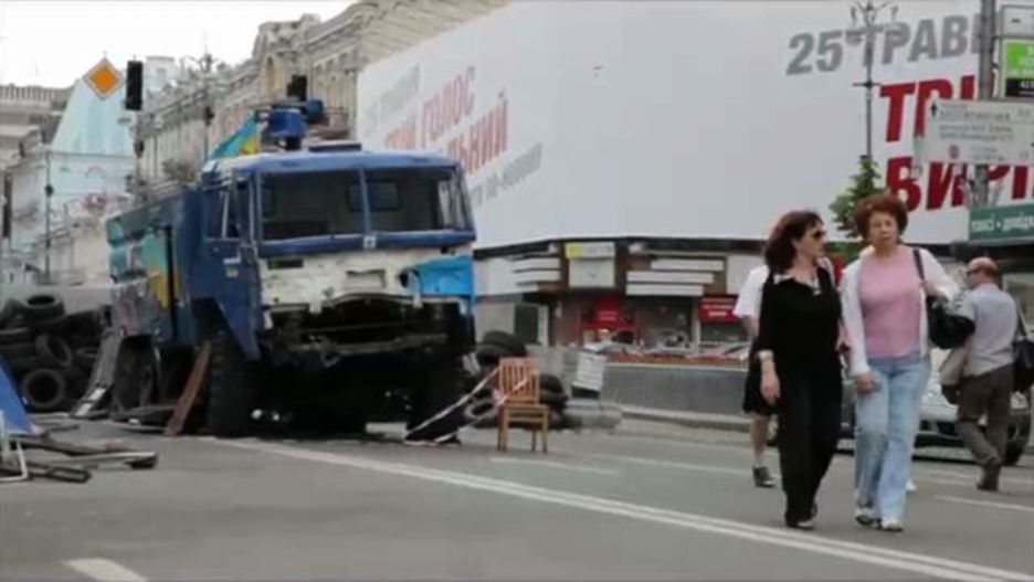 Una persona pasea por el Maidán ante un cartel gubernamental para fomentar el voto. (Juan TEIXEIRA)