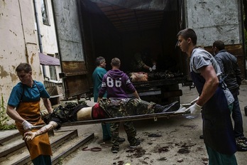Cadáveres de milicianos prorrusos son descargados de un camión en Donetsk. (Fabio BUCCIARELLI / AFP PHOTO)