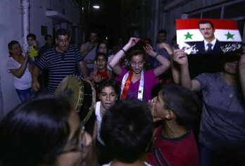 Varios ciudadanos festejan en las calles la victoria de Al-Assad. (Louai BESHARA/AFP PHOTO)