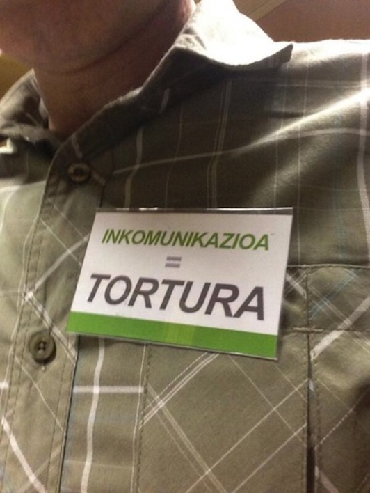 «Inkomunikazioa = Tortura» dioten txarteltxoak eraman dituzte EH Bilduko legebiltzarkideek. (@julenaretakoa)