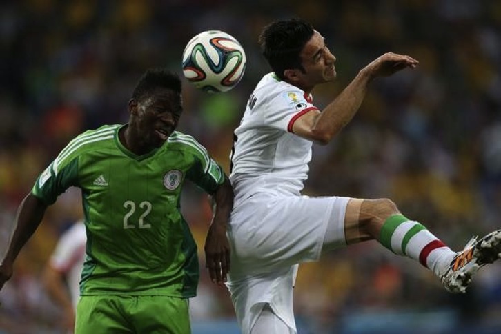El exrojillo Nekounam salta con el nigeriano Omeruo. (Behrouz MEHRI / AFP PHOTO) 