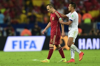 Alexis consuela a su compañero en el Barça Iniesta, héroe español hace cuatro años en Sudáfrica. (Martin BERNETTI / AFP PHOTO)