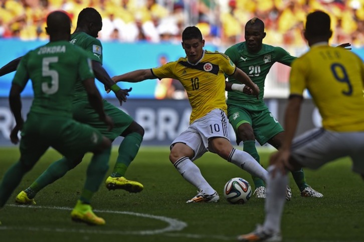 James Rodríguez, autor del primer gol, rodeado de jugadores africanos. (Eitan ABRAMOVICH / AFP PHOTO)