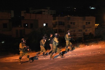 Soldados israelíes se llevan detenido a un palestino en Belén. (Musa al-SHAER/AFP) 