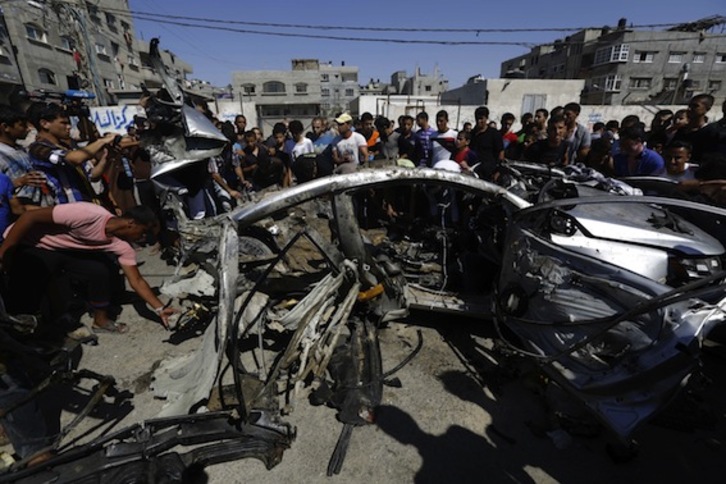 Ciudadanos de Gaza observan los daños provocados por el ataque israelí. (Mohammed ABED/AFP PHOTO)