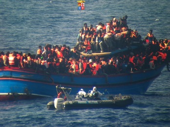 Imagen distribuida por la Marian italiana en la que se ve a una lancha de salvamento acercarse a la embarcación que transportaba a los inmigrantes africanos. (AFP)