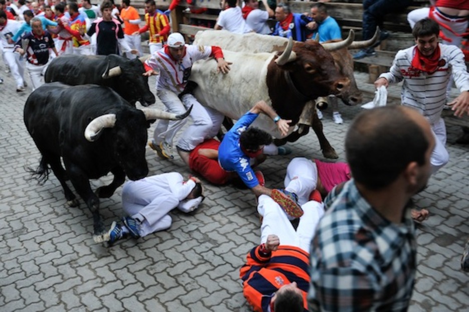 Un mozo, atrapado entre los animales mientras otros quedan en el suelo. (Idoia ZABALETA/ARGAZKI PRESS) Un mozo, atrapado entre los animales mientras otros quedan en el suelo. (Idoia ZABALETA/ARGAZKI PRESS)
