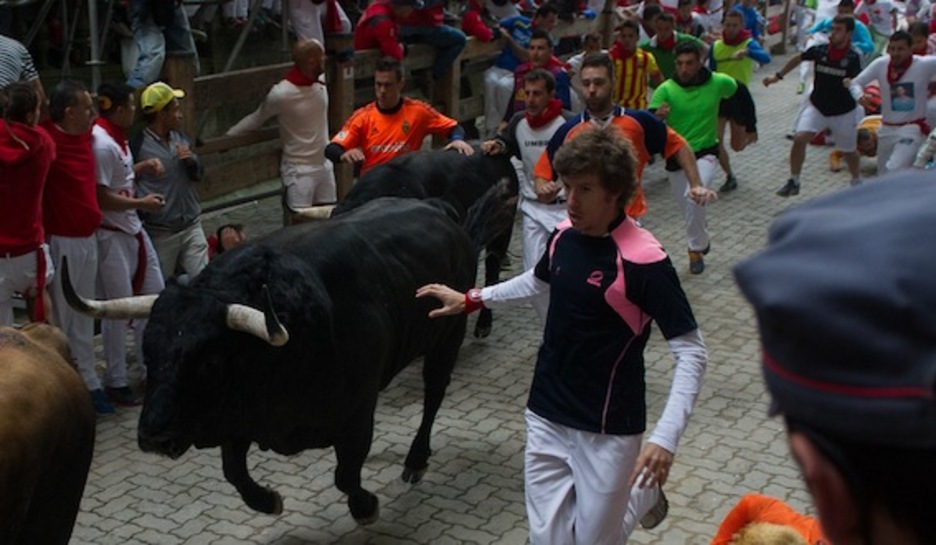 Un mozo corre junto a un toro en el tramo de acceso a la plaza. (Raul BOGAJO/ARGAZKI PRESS) Un mozo corre junto a un toro en el tramo de acceso a la plaza. (Raul BOGAJO/ARGAZKI PRESS)