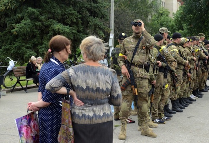 Vecinas de la Slaviansk, junto a soldados ucranianos. (Sergey BOBOK/AFP PHOTO)