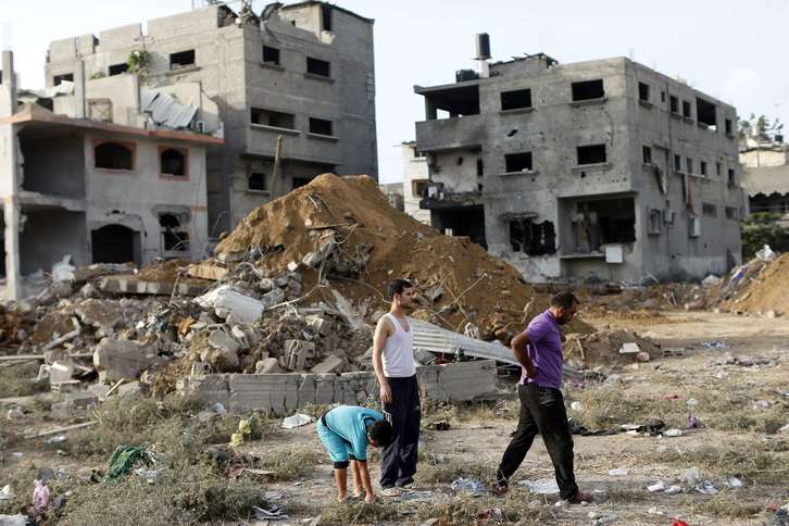 Palestinos en los escombros de edificios tras los ataques aéreos. (Thomas COEX / AFP)