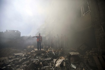 Servicios de emergencias palestinos inspeccionan un edificio derribado por la aviación israelí. (Mahmud HAMS/AFP)
