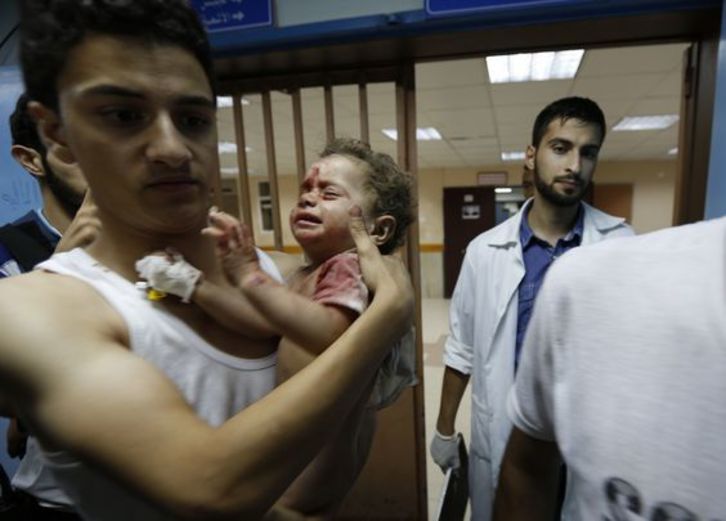 Un hombre traslada al hospital a su hijo herido en la ofensiva. (Mohammed ABED/AFP)