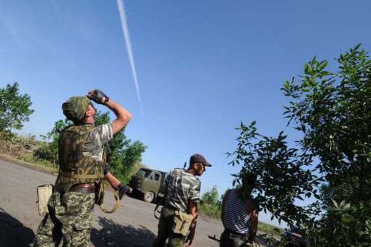 Activistas prorrusos observan la estela de un avión ucraniano sobre Donetsk. (Dominique FAGET/AFP)
