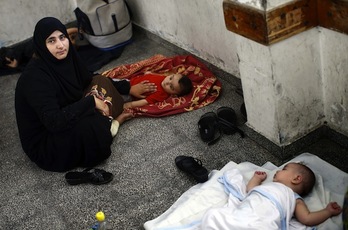Una mujer y dos niños refugiados en un edificio de Naciones Unidos. (Thomas COEX / AFP PHOTO) 