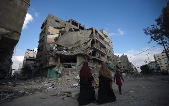 Dos mujeres pasan delante de un edificio destruido por las bombas en Gaza. (Mahmud HAMS/AFP) 