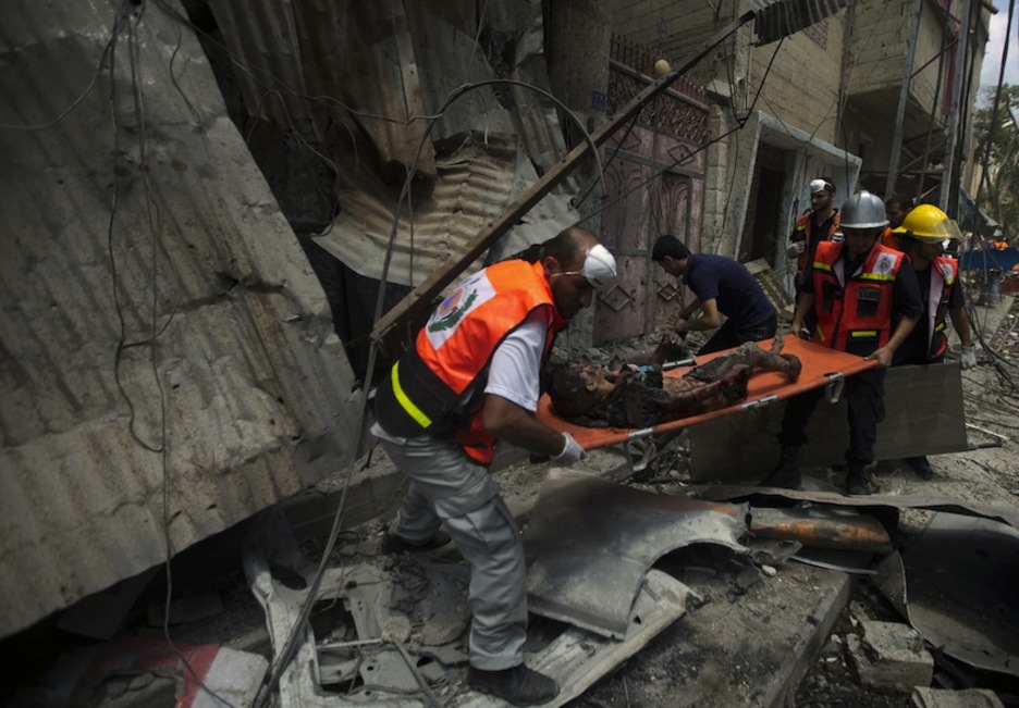 Los equpos de emergencias resactan el cadáver de un niño en Shejaiya. (Mahmud HAMS/AFP)
