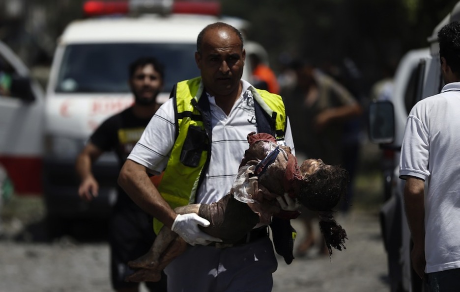 Un médico traslada a una niña herida tras el bombardeo. (Thomas COEX/AFP)