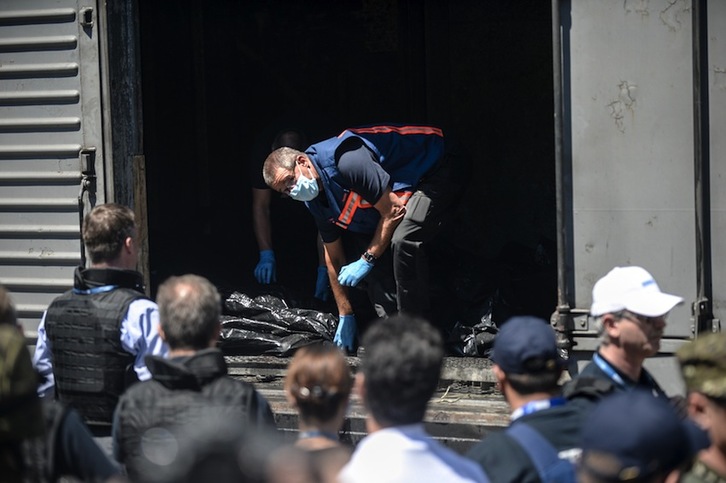 Miembros de la OSCE examinan los vagones en los que se han introducido los cadáveres. (Bulent KILIC/AFP)