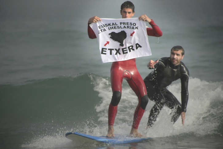 Surflariak, preso eta iheslarien etxeratzearen aldeko banderolarekin. (Ira LEKUE)