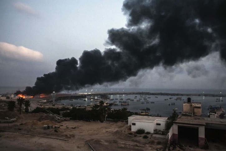 Una gran columna de humo se eleva esta madrugada desde un edificio del puerto de Gaza. (Loulou D'AKI  / AFP PHOTO)