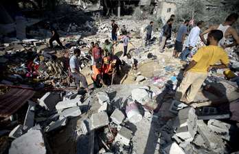 Palestinos buscan entre los escombros de un edificio atacado en Rafah. (Mahmud HAMS / AFP)
