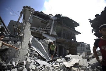Varios palestinos, rodeados de escombros en el campo de refugiados de Jabalia, en Gaza. (Mahmud HAMS/AFP PHOTO)
