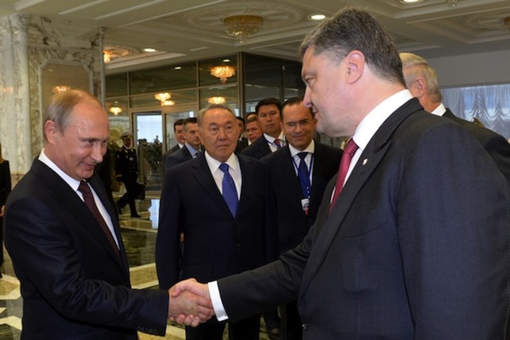 Saludo entre el presidente ruso, Vladimir Putin, y Petro Poroshenko, mandatario ucraniano. (Sergei BONDARENKO/AFP PHOTO)