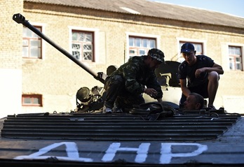 Activistas prorrusos reparan un carro de combate al sureste de Donetsk. (Francisco LEONG/AFP)