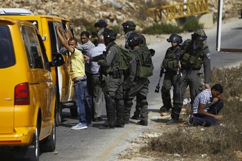 Soldados israelíes cachean a varios palestinos, en una reciente imagen tomada en Cisjordania. (Abbas MOMANI/AFP PHOTO)