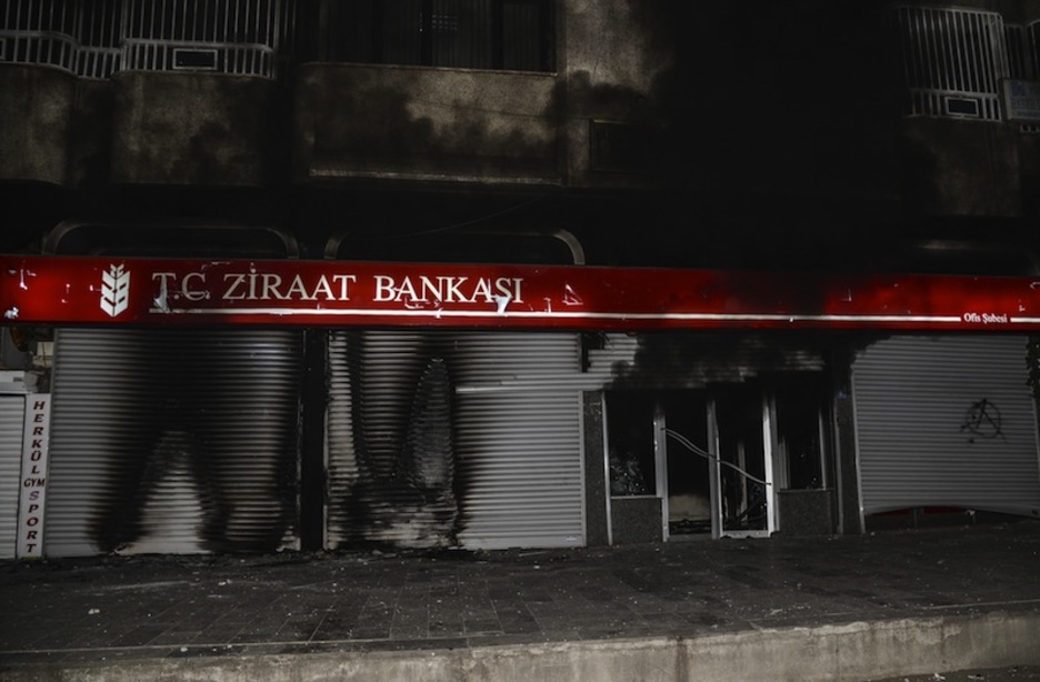 Ataque contra una sucursal del banco público turco en Diyarbakir, en denuncia por la pasividad de Erdogan. (Ilyas AKENGIN / AFP)