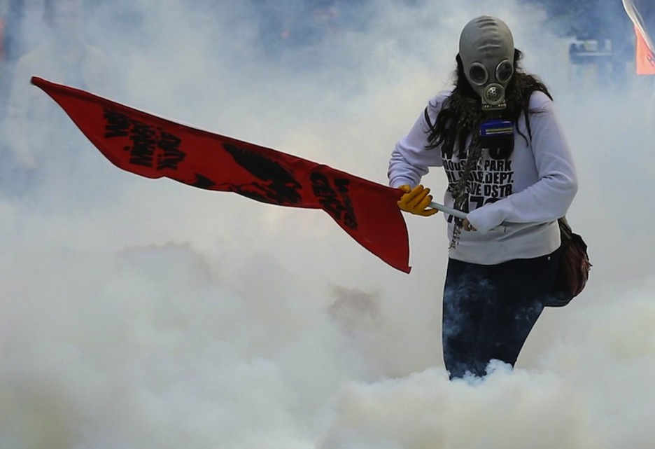 Una manifestante se defiende con una máscara del gas lacrimógeno de la Policía turca en Ankara. (Adem ALTAN / AFP)  