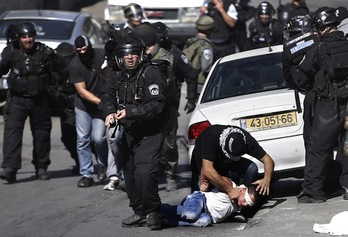 Un policía israelí inmoviliza a un joven palestino al que han vendado los ojos. (Thomas COEX/AFP PHOTO) 
